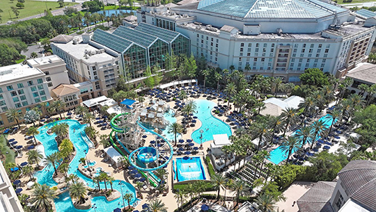 A panoramic view of the resort's pool and water park, showcasing slides and lounging areas under a clear blue sky.