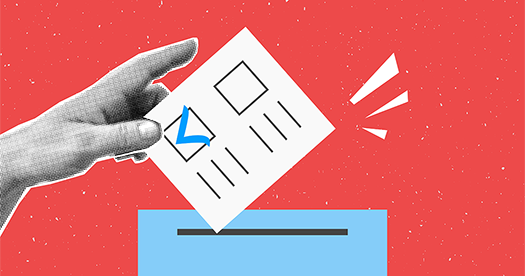 A hand dropping a ballot into a ballot box.